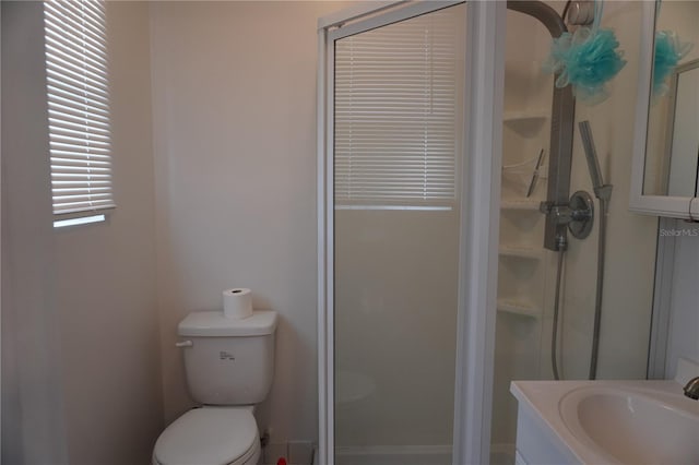 bathroom featuring toilet, a shower stall, and vanity