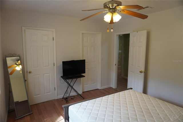 unfurnished bedroom featuring ceiling fan, wood finished floors, visible vents, and baseboards