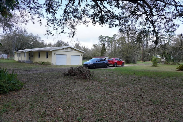 view of yard with an attached garage and driveway