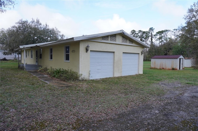 garage featuring driveway and a shed