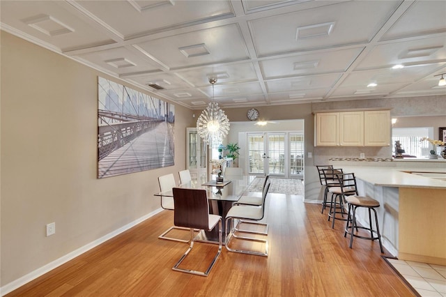 dining area with light wood-type flooring, french doors, coffered ceiling, and baseboards