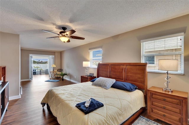 bedroom with ceiling fan, a textured ceiling, baseboards, and wood finished floors