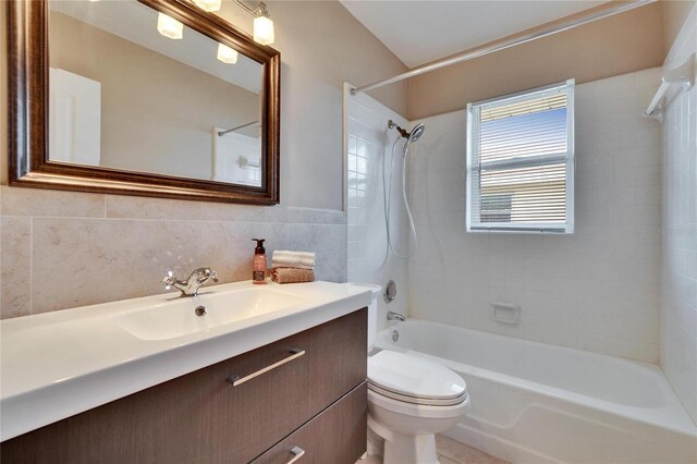 bathroom featuring tile walls, shower / bath combination, vanity, and toilet