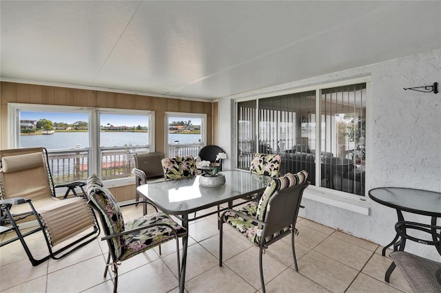 sunroom featuring a water view