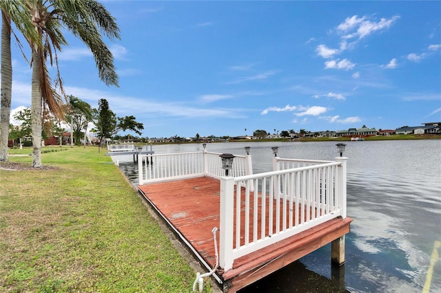 dock area with a lawn and a water view