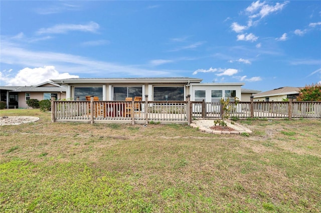 view of front facade with a deck, fence, and a front lawn