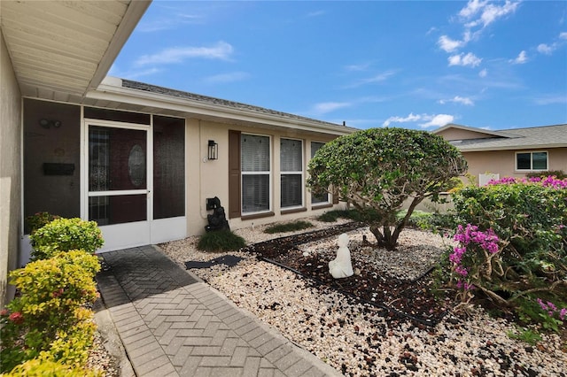 exterior space featuring a sunroom and stucco siding