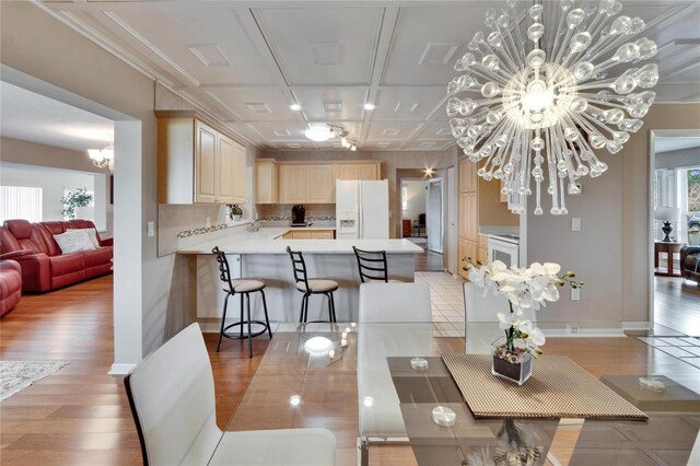 dining area with light wood-style flooring and a notable chandelier