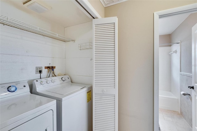 washroom with washing machine and dryer, laundry area, and light tile patterned floors