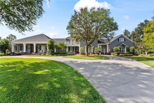 view of front of house with curved driveway and a front yard