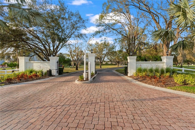 view of gate with a fenced front yard