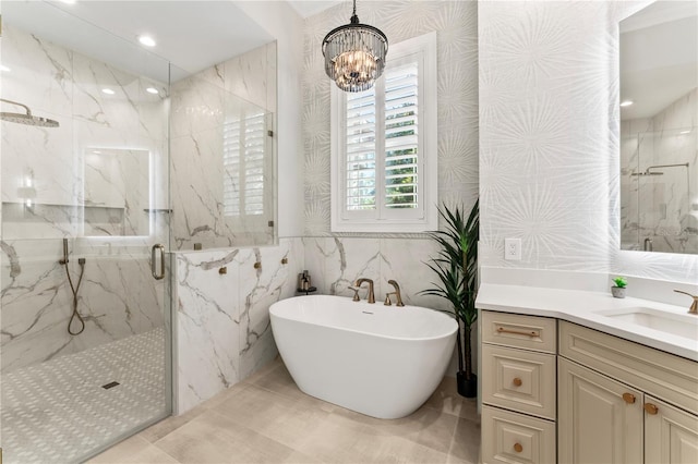 bathroom with a marble finish shower, recessed lighting, an inviting chandelier, vanity, and a freestanding tub