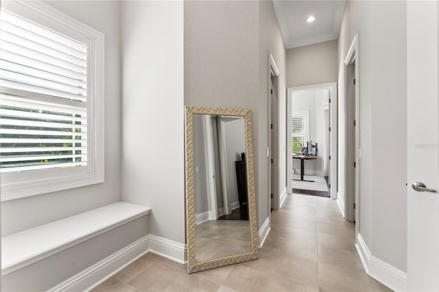 corridor with recessed lighting, crown molding, baseboards, and light tile patterned floors