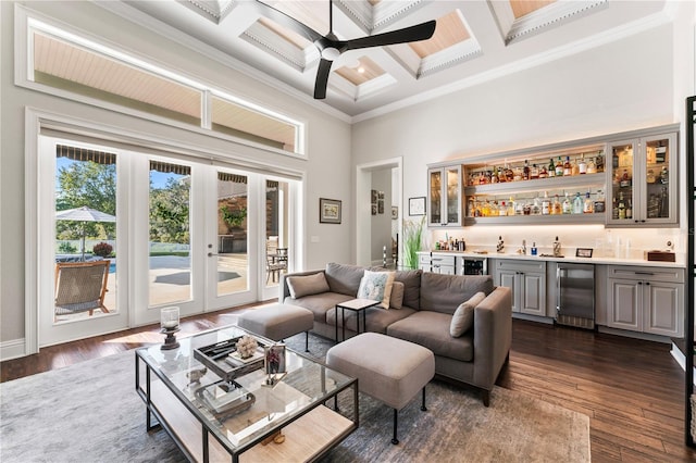 living area with wine cooler, dark wood-type flooring, a high ceiling, wet bar, and crown molding