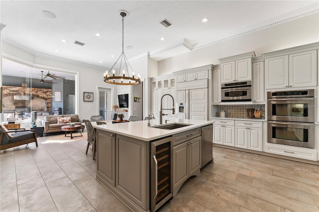 kitchen with beverage cooler, visible vents, appliances with stainless steel finishes, gray cabinetry, and a sink