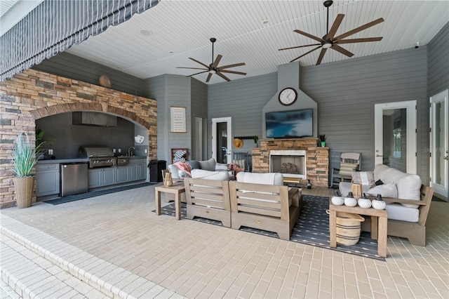 view of patio with an outdoor living space with a fireplace and area for grilling