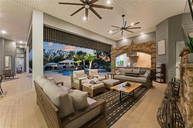 view of patio / terrace featuring an outdoor living space with a fireplace, an outdoor pool, and a ceiling fan