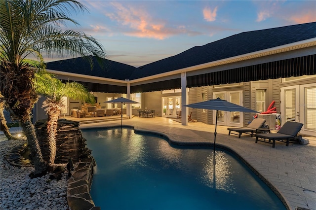 outdoor pool featuring french doors and a patio area