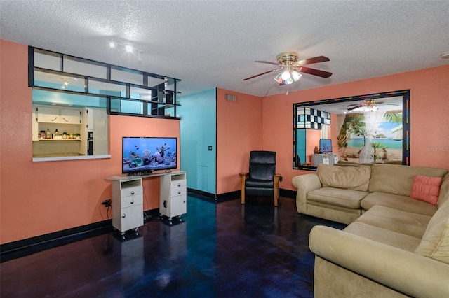 living room with a ceiling fan, visible vents, a textured ceiling, and baseboards