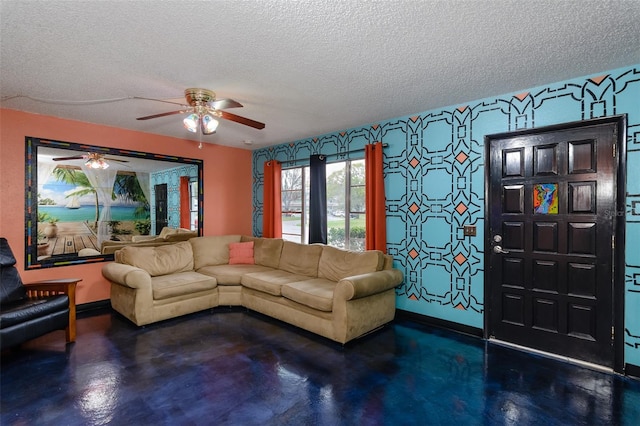 living room featuring finished concrete floors, a textured ceiling, baseboards, and a ceiling fan