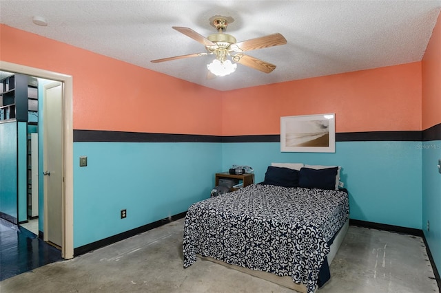 bedroom featuring a ceiling fan, a textured ceiling, baseboards, and concrete flooring