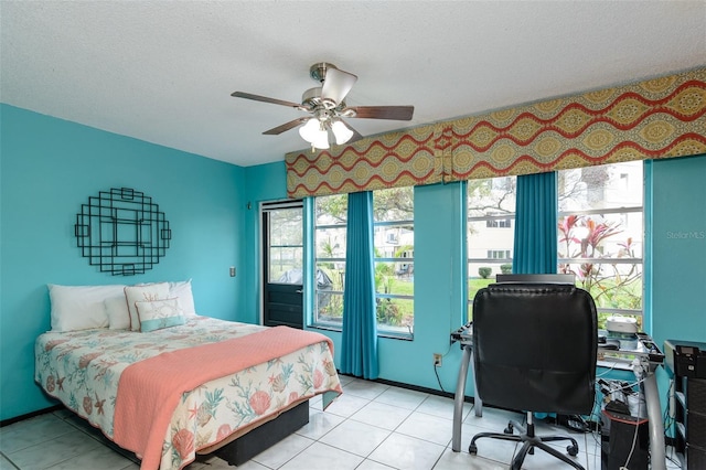 bedroom with a ceiling fan, a textured ceiling, baseboards, and light tile patterned floors