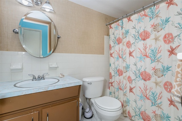 bathroom with toilet, wallpapered walls, tile walls, and vanity