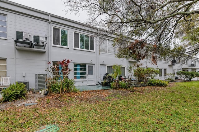 rear view of property featuring cooling unit and a yard