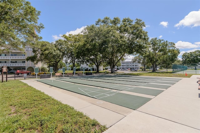 view of home's community featuring shuffleboard and fence