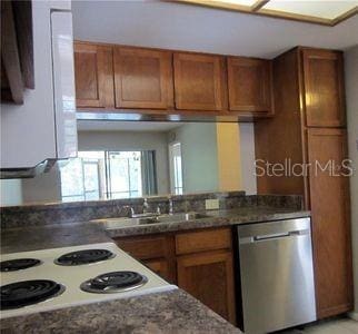 kitchen featuring a sink, brown cabinetry, and stainless steel dishwasher