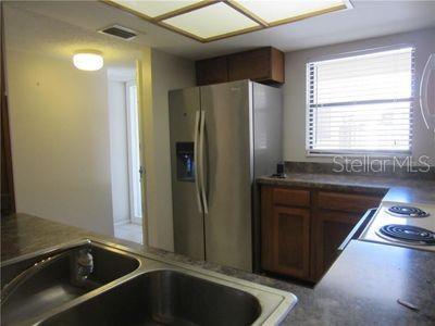 kitchen featuring dark countertops, stainless steel fridge, and visible vents