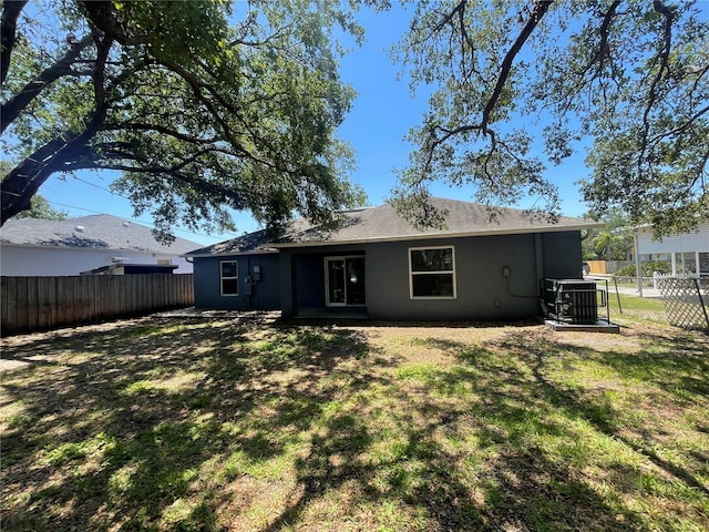 rear view of house featuring stucco siding and cooling unit