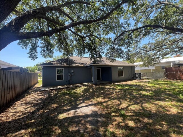 back of house with fence and stucco siding