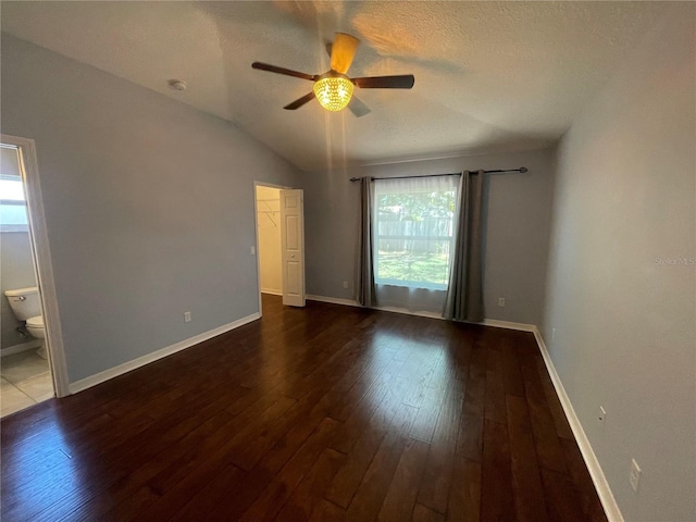 unfurnished room featuring ceiling fan, hardwood / wood-style floors, lofted ceiling, baseboards, and a textured ceiling