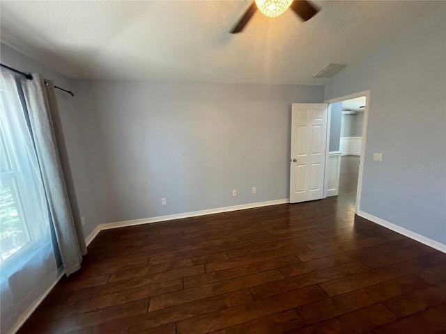 empty room featuring dark wood-style floors, ceiling fan, and baseboards