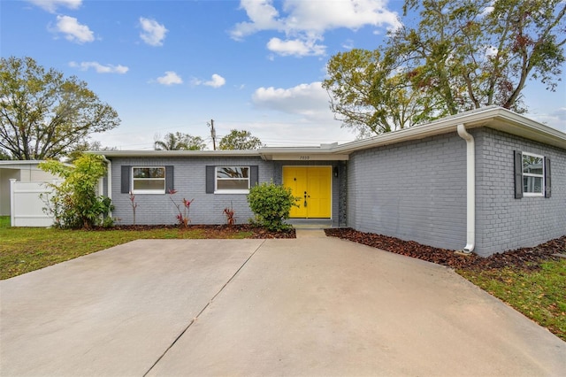 ranch-style house with a patio area, brick siding, and fence