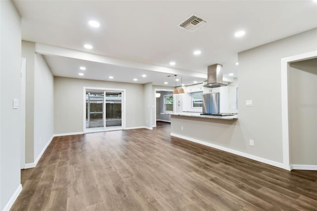 unfurnished living room featuring baseboards, visible vents, dark wood finished floors, and recessed lighting