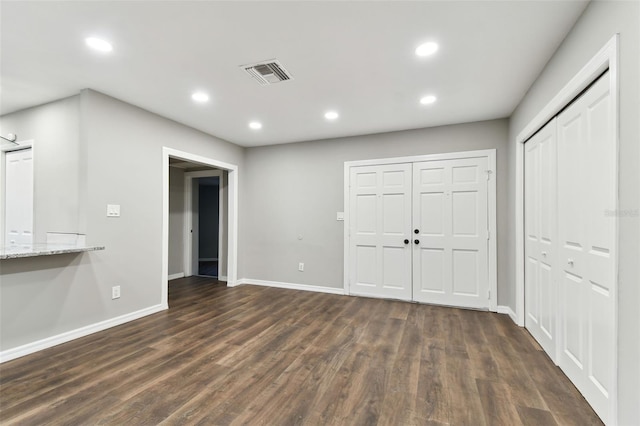 interior space featuring dark wood-style floors, recessed lighting, visible vents, and baseboards