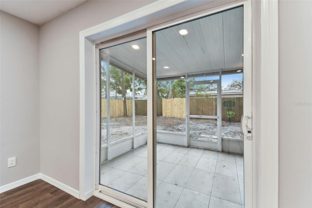 doorway to outside featuring a wealth of natural light, light tile patterned flooring, baseboards, and recessed lighting