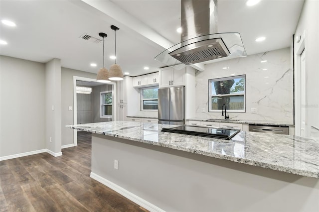 kitchen with island range hood, light stone counters, hanging light fixtures, stainless steel appliances, and white cabinetry