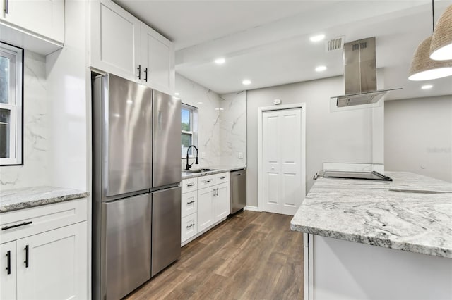 kitchen with stainless steel appliances, island exhaust hood, decorative light fixtures, and white cabinets