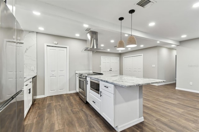 kitchen with pendant lighting, island exhaust hood, stainless steel appliances, visible vents, and white cabinets