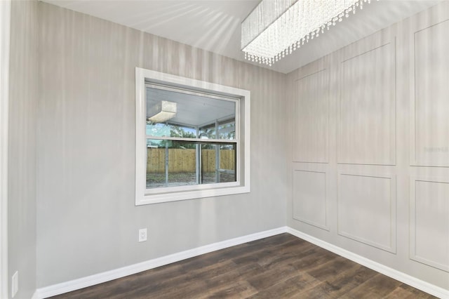 spare room with dark wood finished floors and baseboards