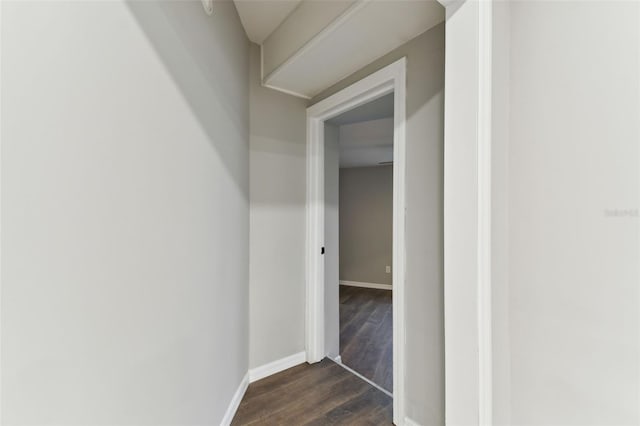 hallway with dark wood-style flooring and baseboards