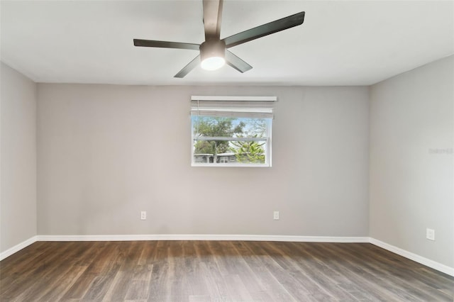 spare room featuring dark wood-style floors, baseboards, and a ceiling fan