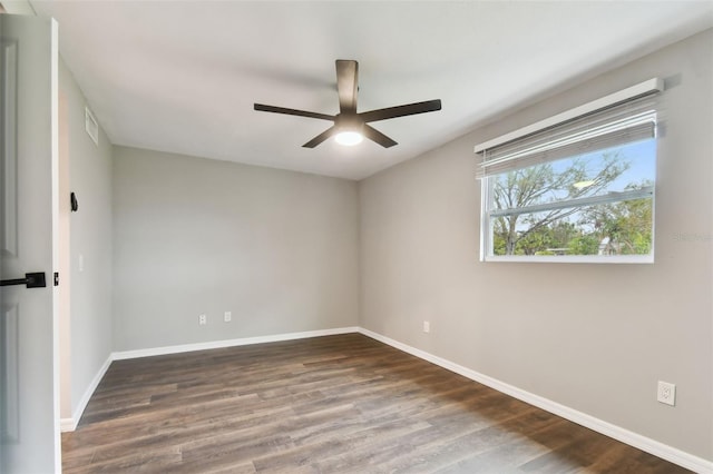 unfurnished room featuring dark wood-type flooring, ceiling fan, and baseboards