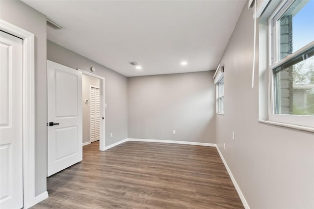 unfurnished room with dark wood-style floors, recessed lighting, visible vents, and baseboards