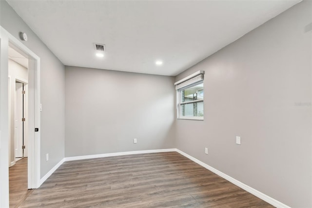 empty room with recessed lighting, visible vents, baseboards, and wood finished floors