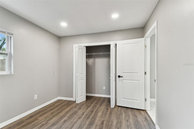 unfurnished bedroom featuring baseboards, dark wood finished floors, a closet, and recessed lighting