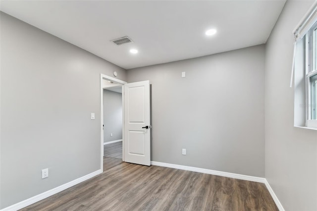 unfurnished room with recessed lighting, wood finished floors, visible vents, and baseboards